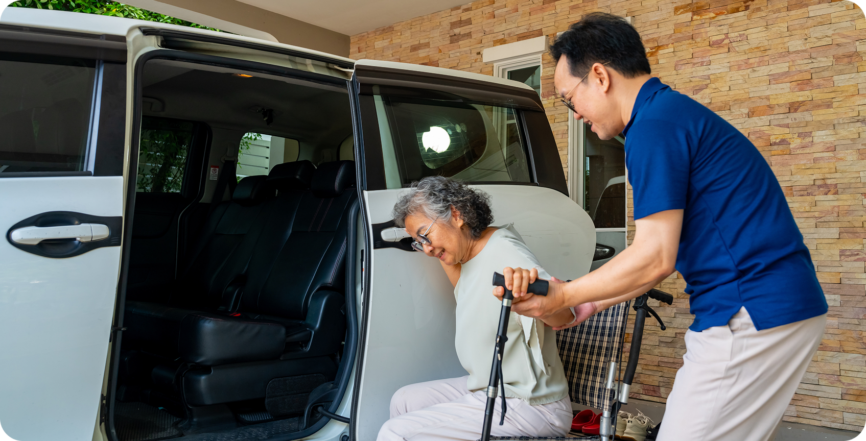 Man helping senior into car