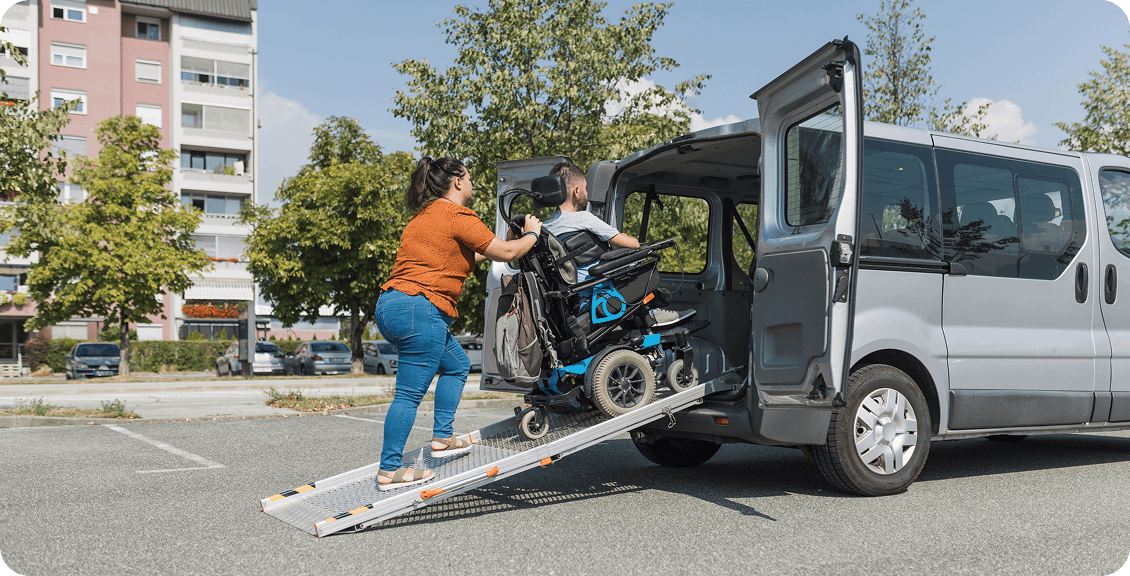 Loading wheelchair into van using ramp.