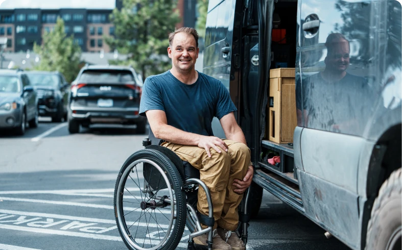 Man in wheelchair beside a van