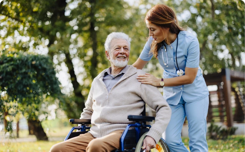 Nurse supporting elderly man in nature