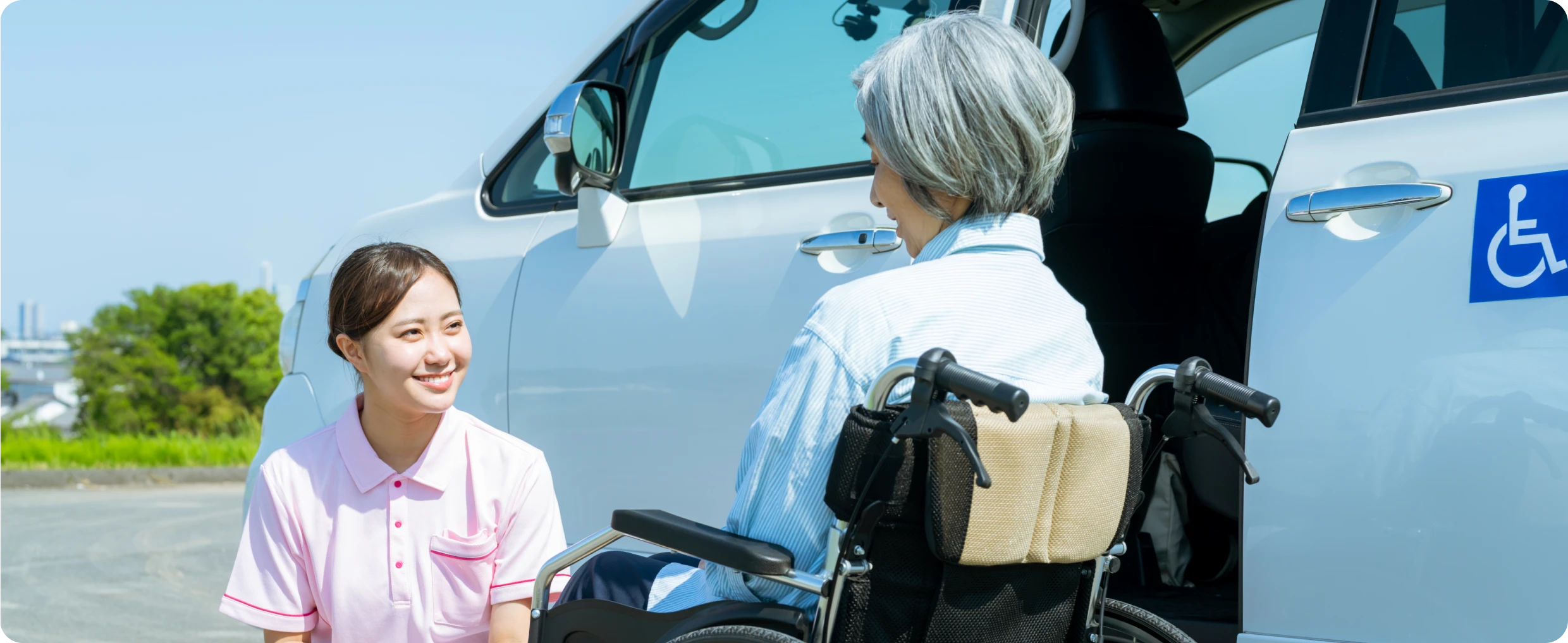 Woman helping senior near adapted vehicle