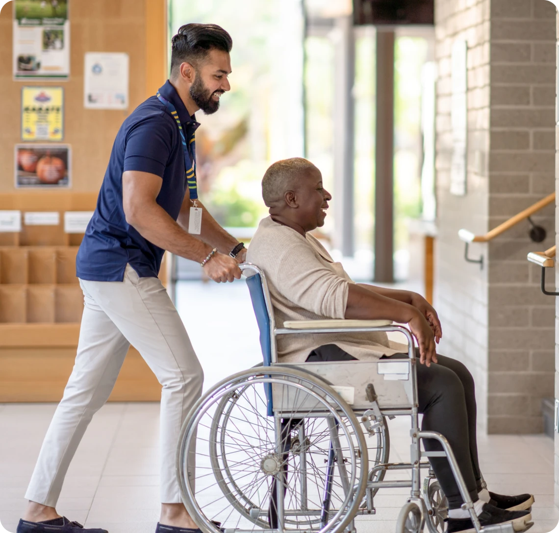 Person helping a wheelchair user indoors